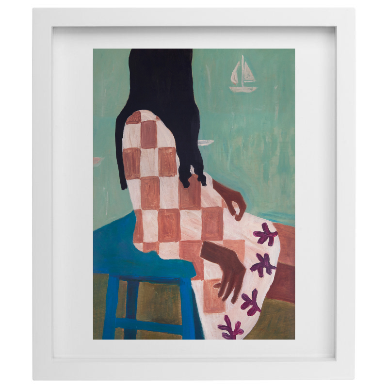 Woman sitting with sailboats in the background artwork in a white frame