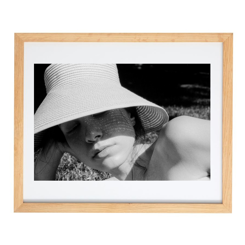 Photograph of a woman laying on the beach in a natural frame
