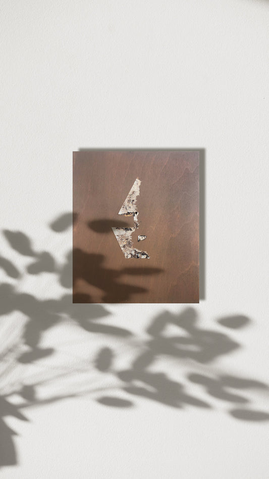 Abstract figure artwork in a neutral palette pictured on the wall