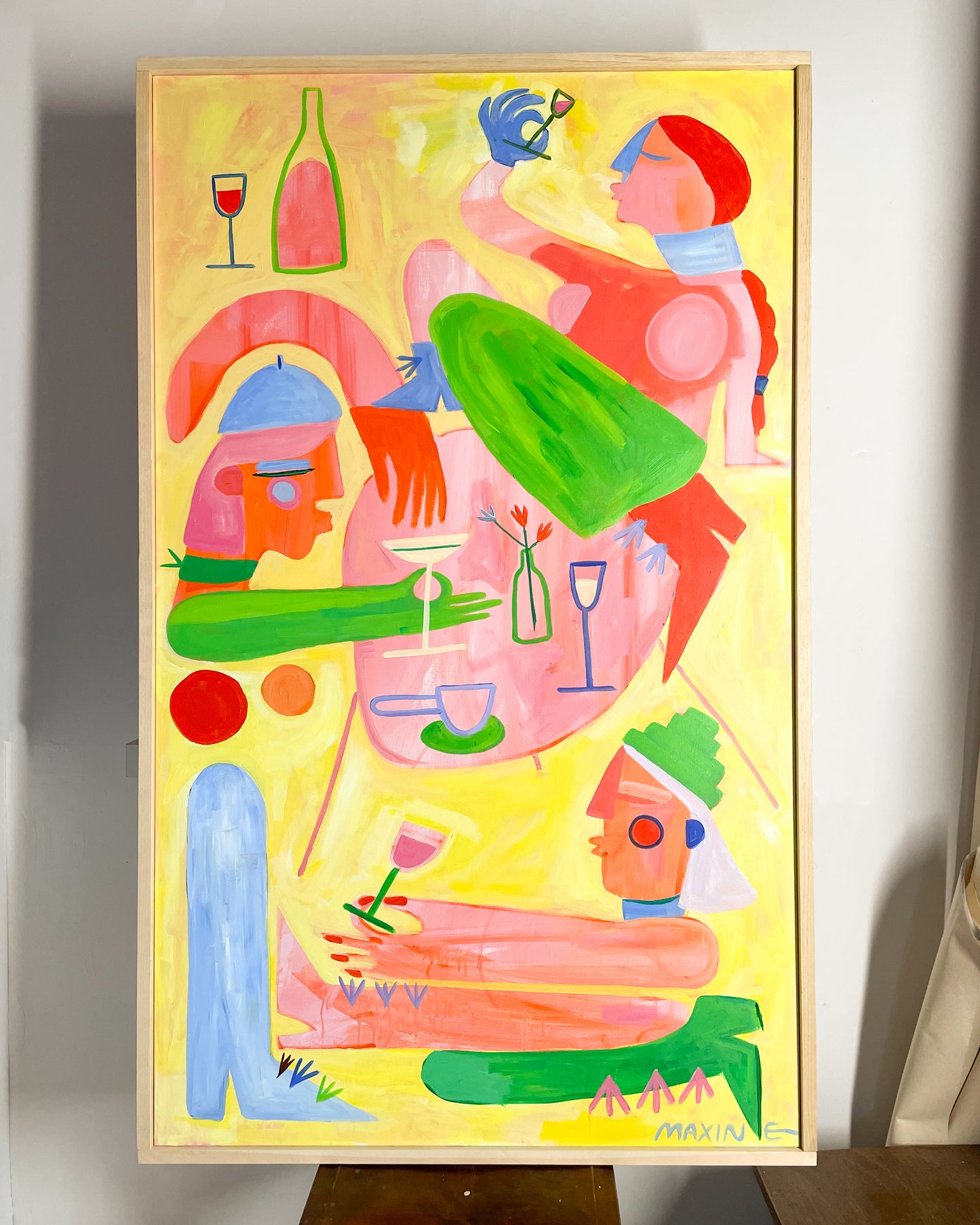 Yellow, green, pink, and blue abstract artwork pictured on the wall