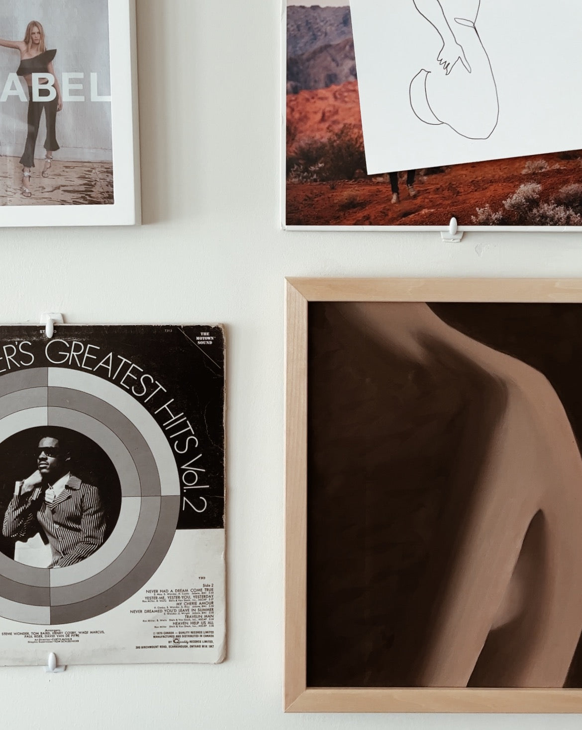 Female figure artwork in neutral colours pictured in a gallery wall