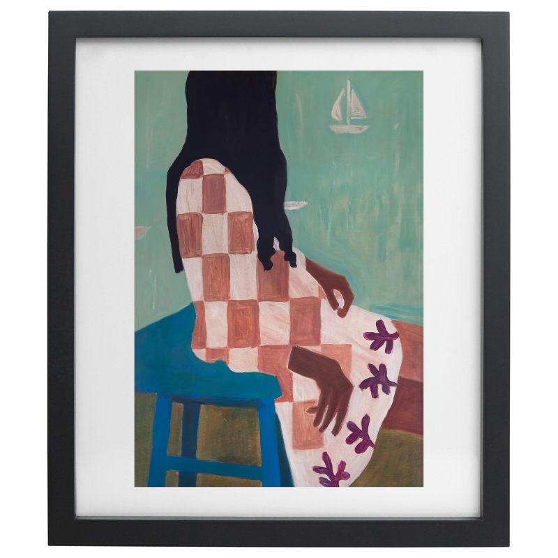 Woman sitting with sailboats in the background artwork in a black frame