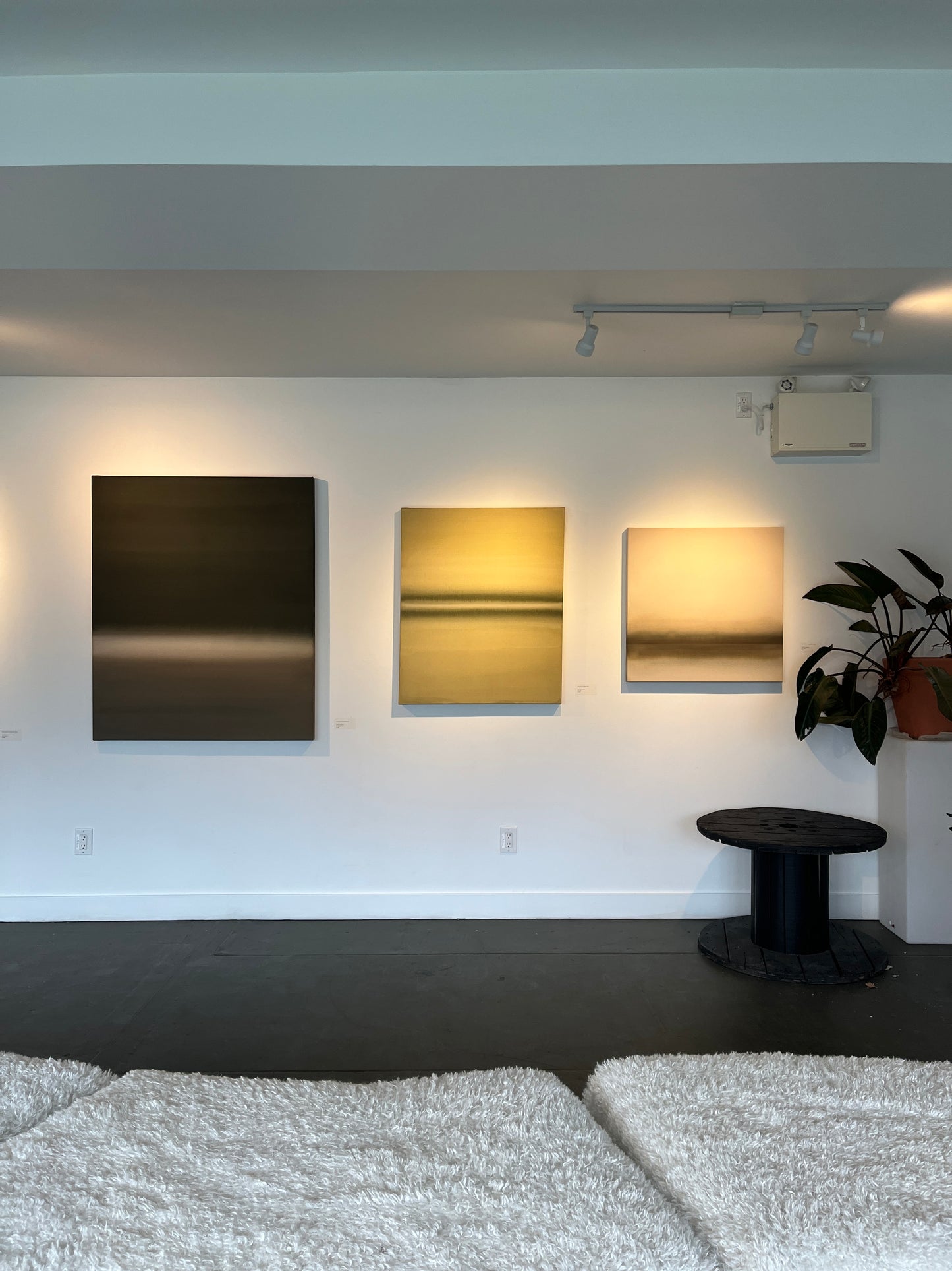 Abstract neutral and green artwork on the wall with other artworks