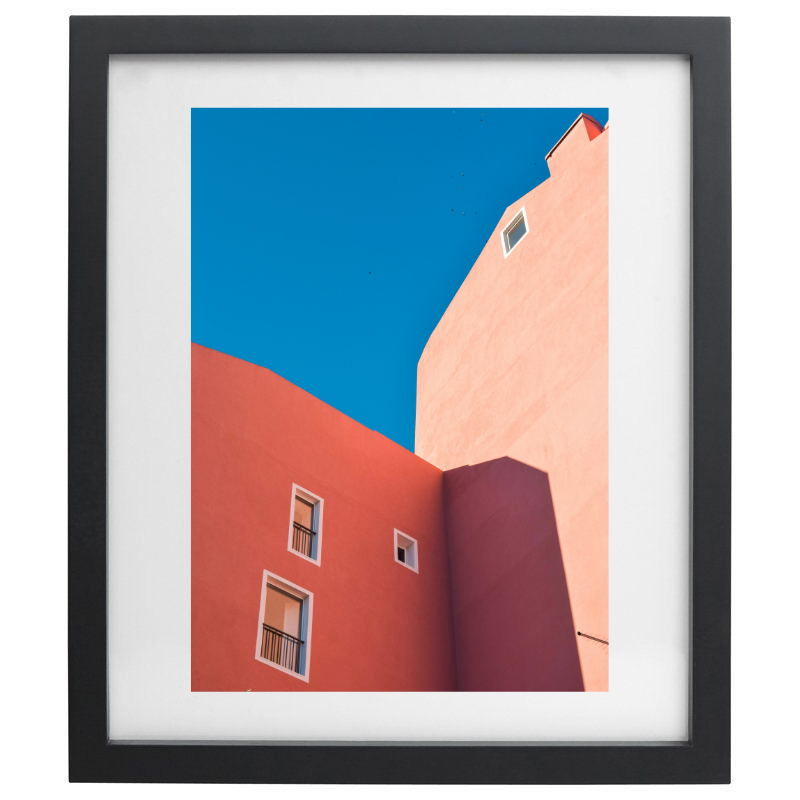 Orange buildings with blue skies photography in a black frame