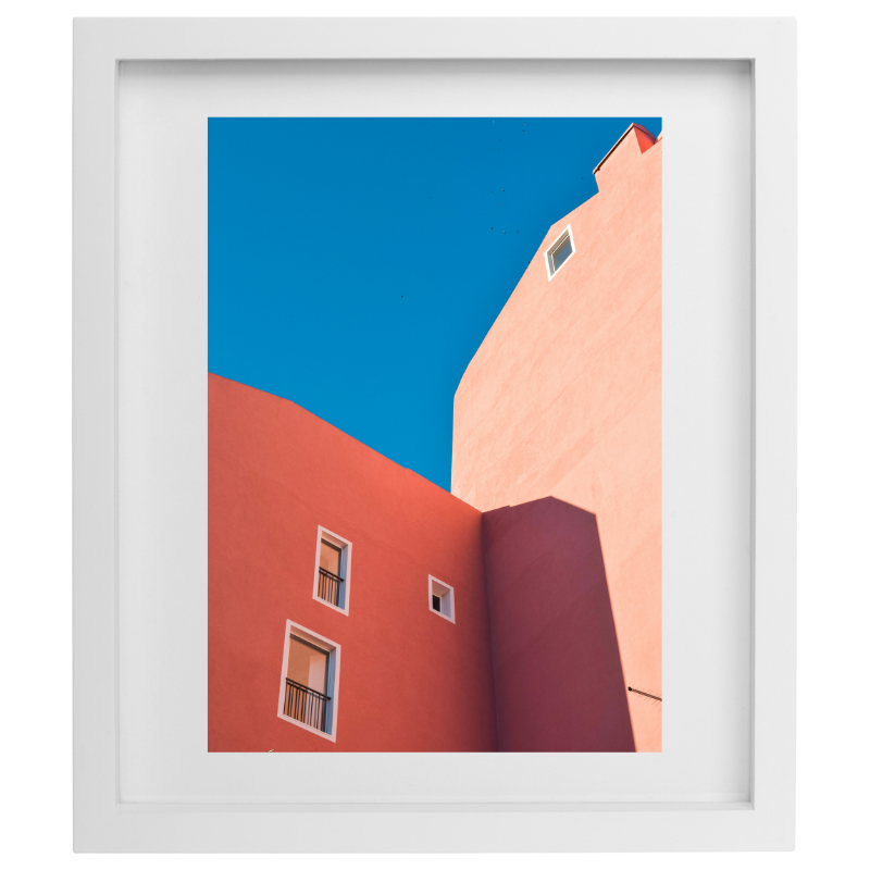 Orange buildings with blue skies photography in a white frame