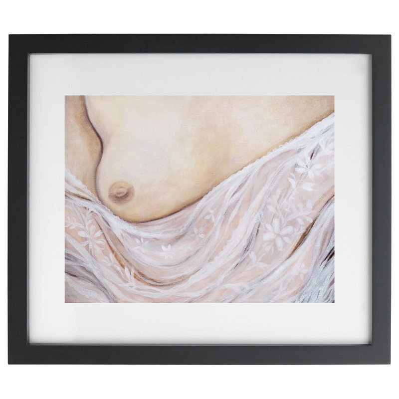 Exposed breast with lace artwork in a black frame