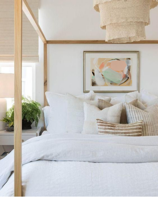 Abstract muted pastel and neutral colour artwork pictured above a bed