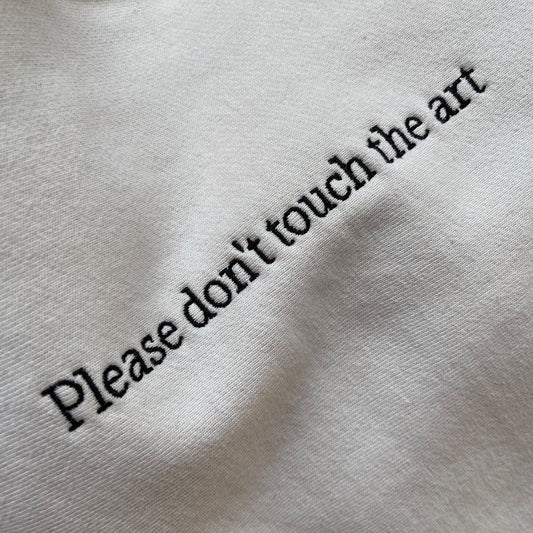 Tacit's "Please Don't Touch the Art" crewneck closeup of embroidery