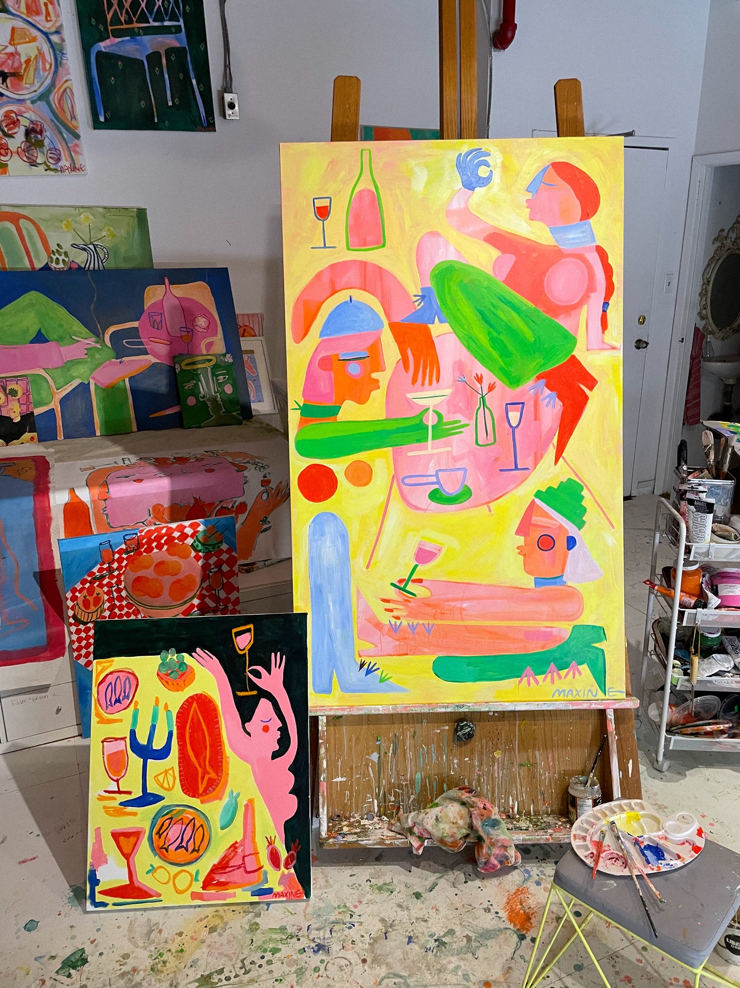 Yellow, green, pink, and blue abstract artwork pictured on an easel
