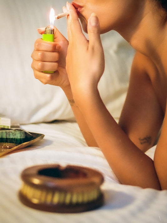 Photograph of a woman smoking on a bed